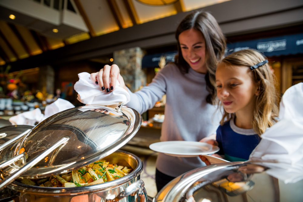 Women and child look into the buffet at Fairmont Chateau Whistler