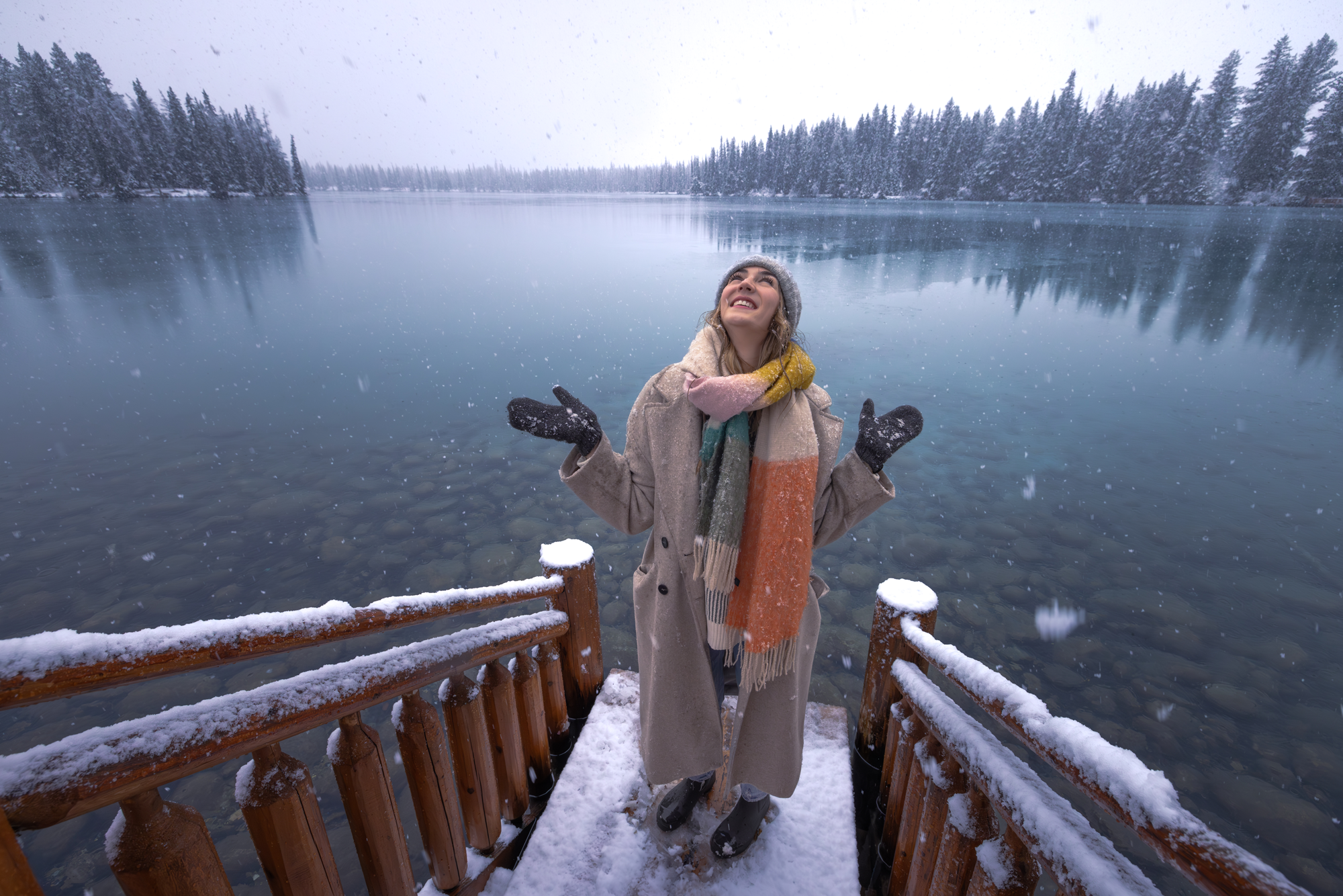 Women stands looking up at the snow on the side of Lac Beauvert in Jasper National Park