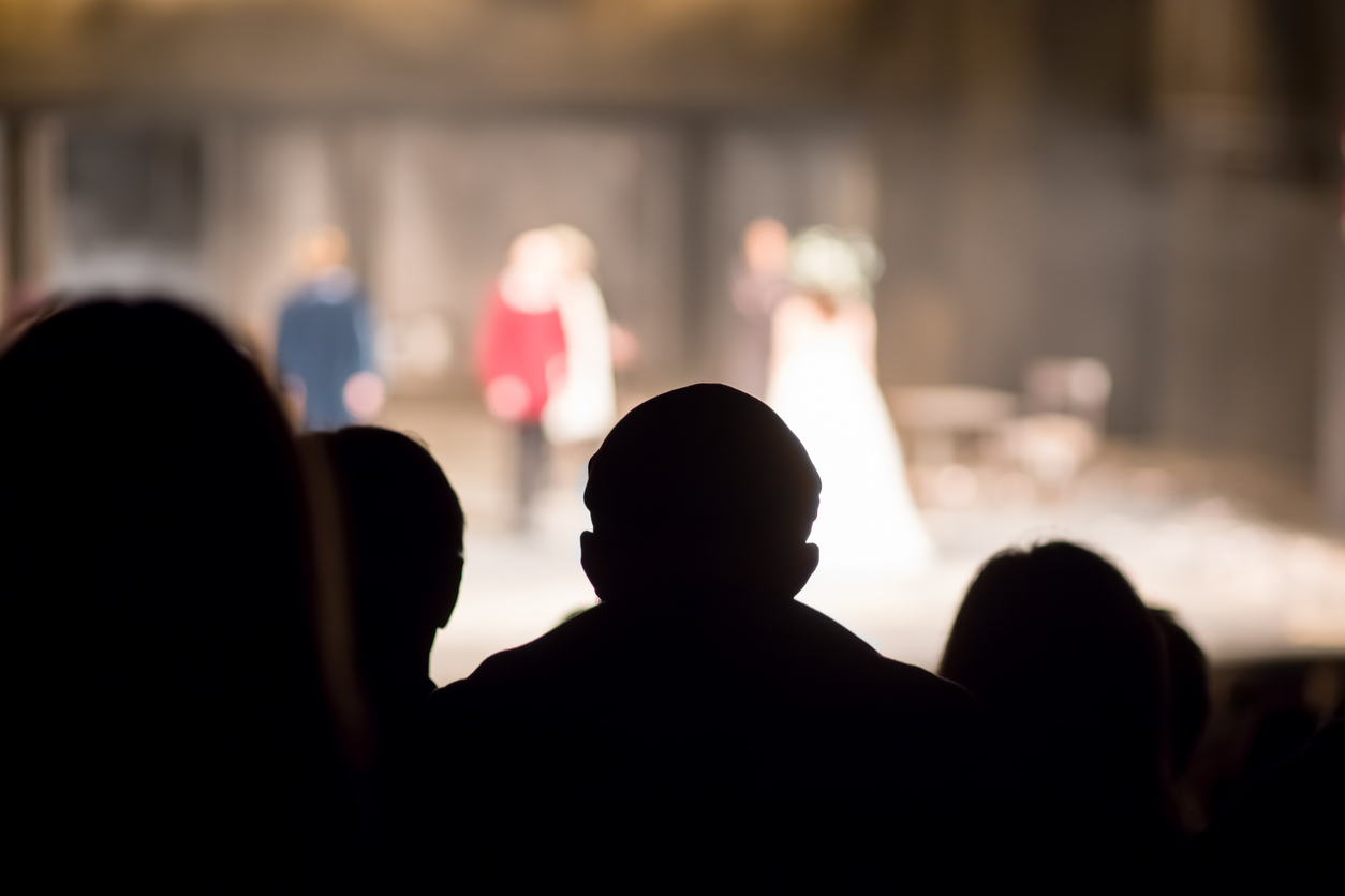 A group of people looking towards a stage which has actors in a play during an arts festival in Whistler