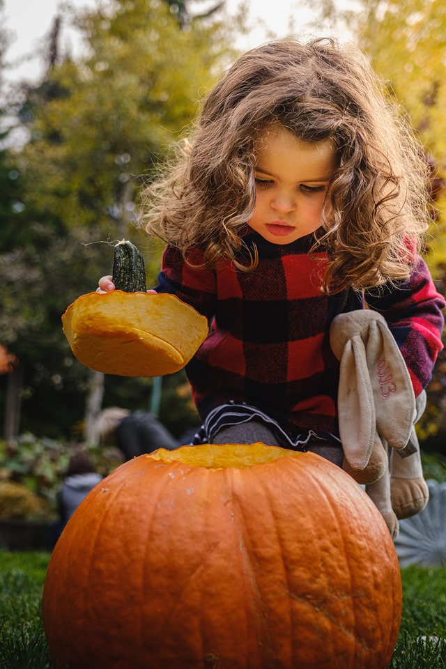 Girl carving a pumpkin during Halloween weekend at Fairmont Chateau Whistler.