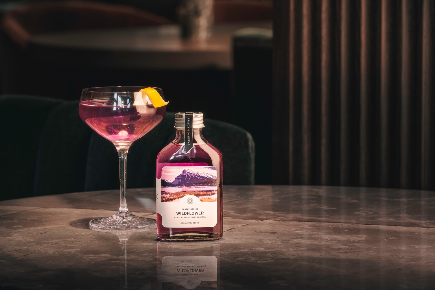 _DSF4398-Enhanced-Edit The Fairmont Banff Springs signature cocktail, Wildflower on the counter with the bottle next to it.