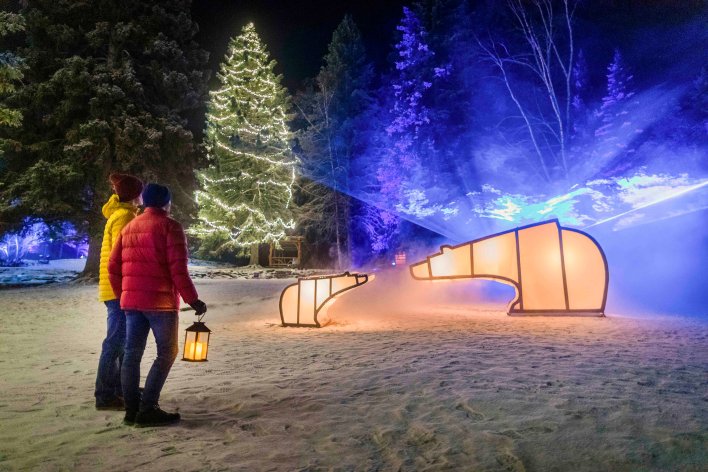 Two people looking at the light displays for the In Search of Christmas Spirit in Banff National Park