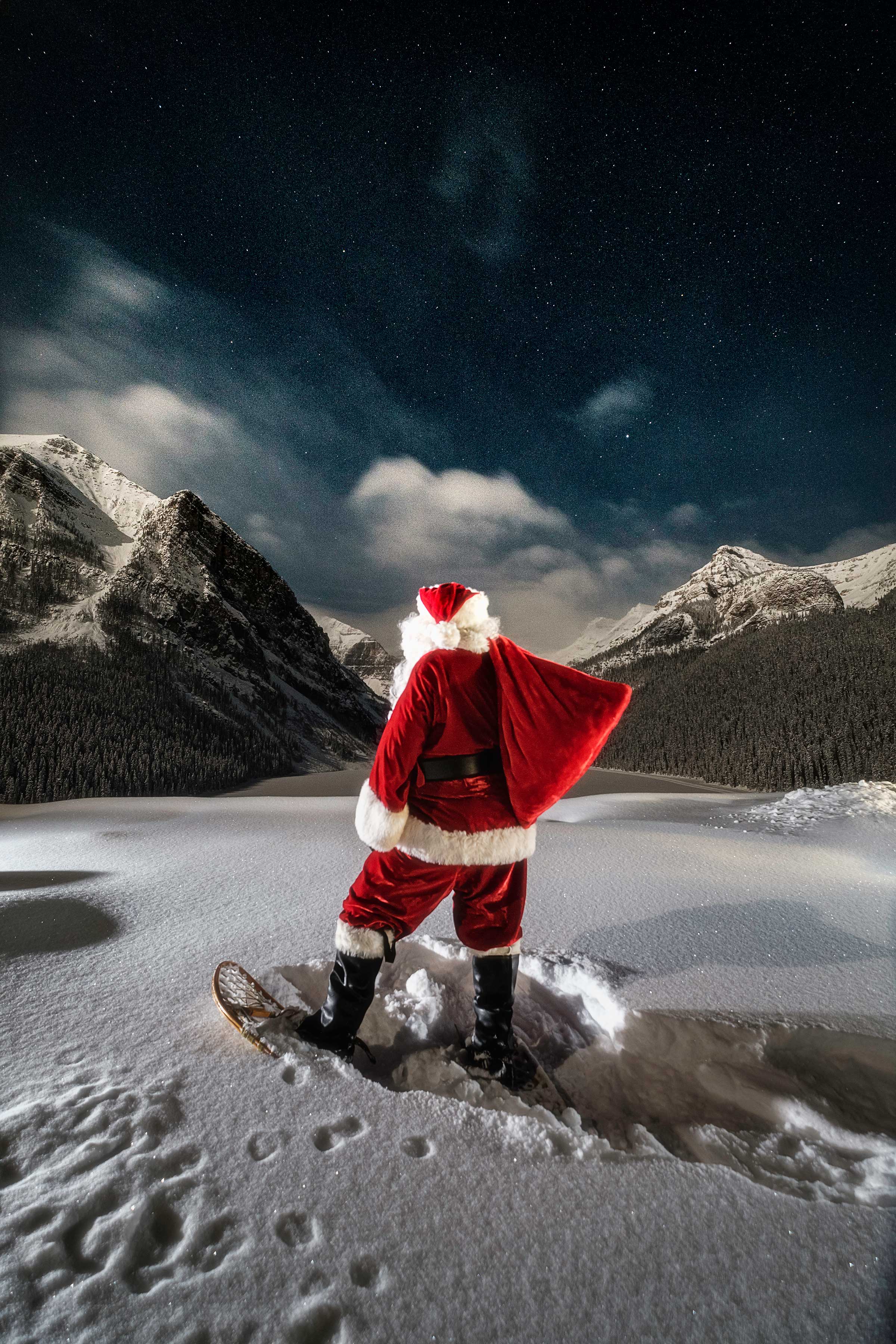 Santa in snowshoes looking at the mountain on Fairmont Chateau Lake Louise