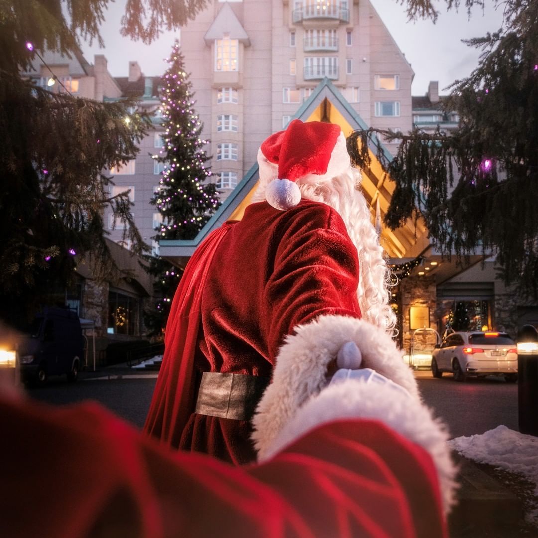 Mom and baby share a moment in front of Fairmont Chateau Whistler at Christmas