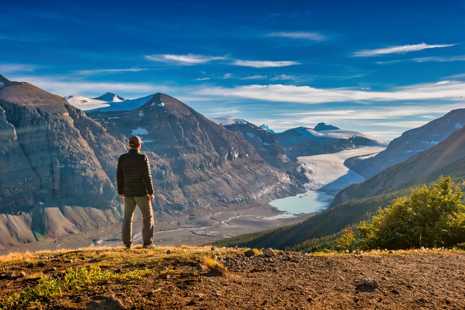 Hiker looking out to glacier and surrounding mountains in Banff National Park.