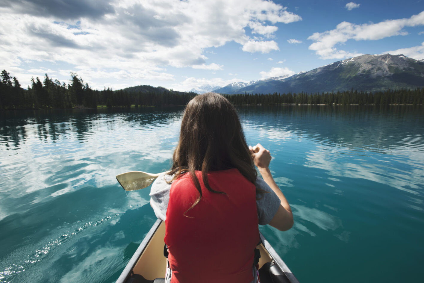 Spring and Summer Lake Louise - Couple canoeing across Lake Louise